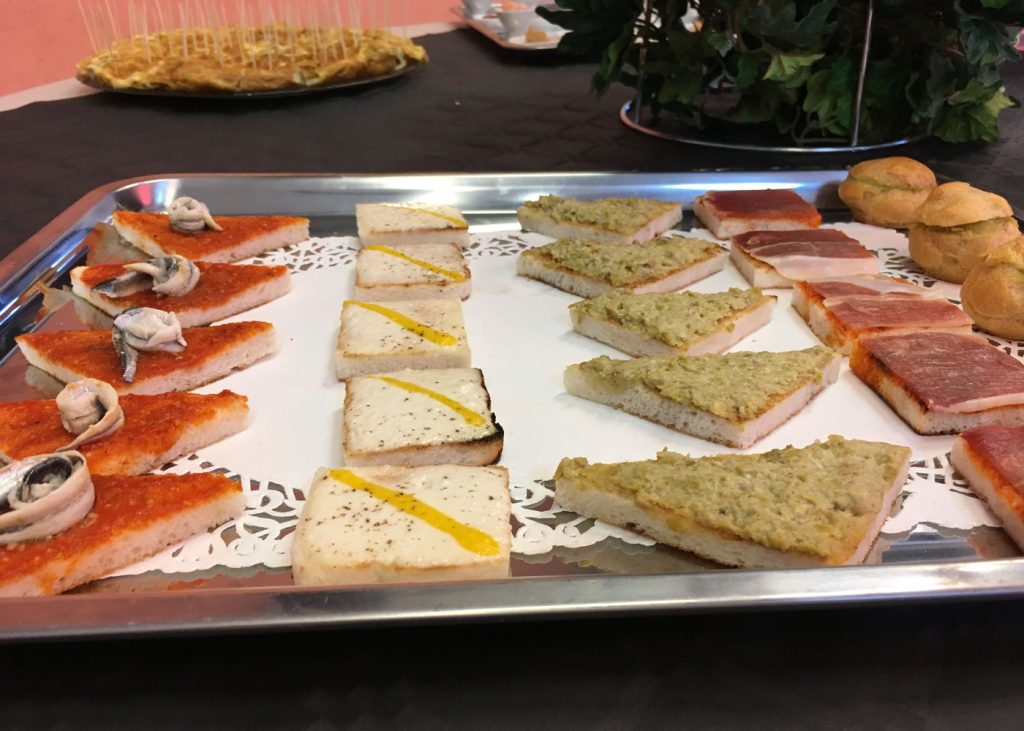 Plateau La Gourmande : rangées de toasts aux anchois, au jambon cru et à la tartinade verte, petits choux au bout